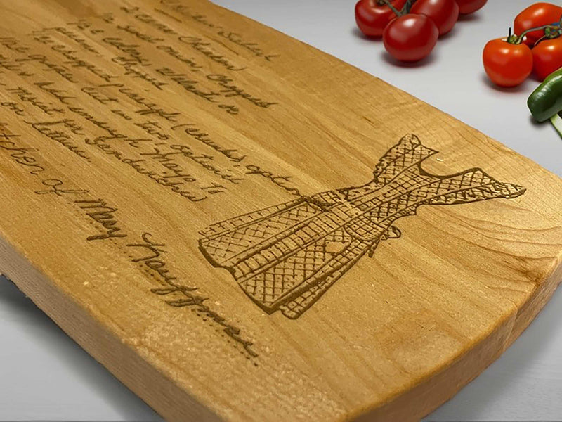 Personalized wooden cutting board with engraved handwriting and a detailed design of a dress.